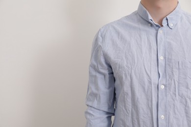 Photo of Man wearing rumpled shirt on white background, closeup