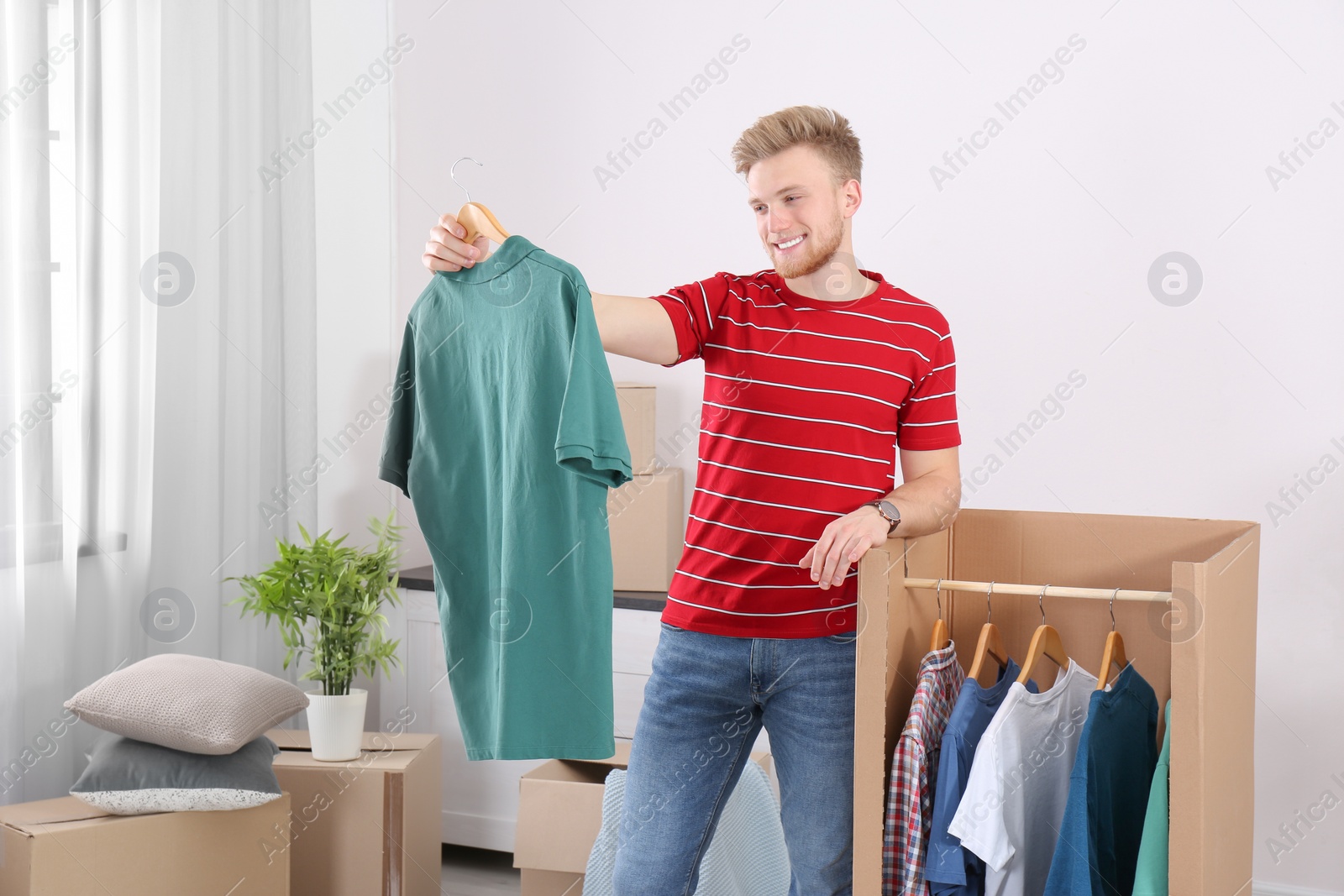 Photo of Young man near wardrobe box at home