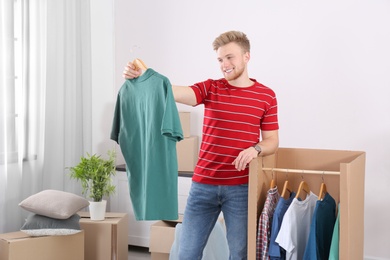 Young man near wardrobe box at home