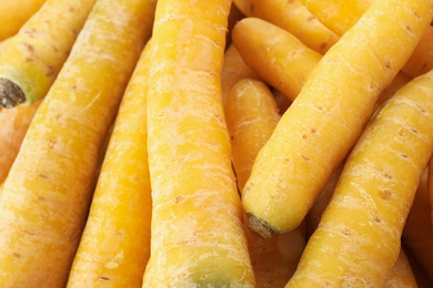 Photo of Fresh raw yellow carrots as background, closeup