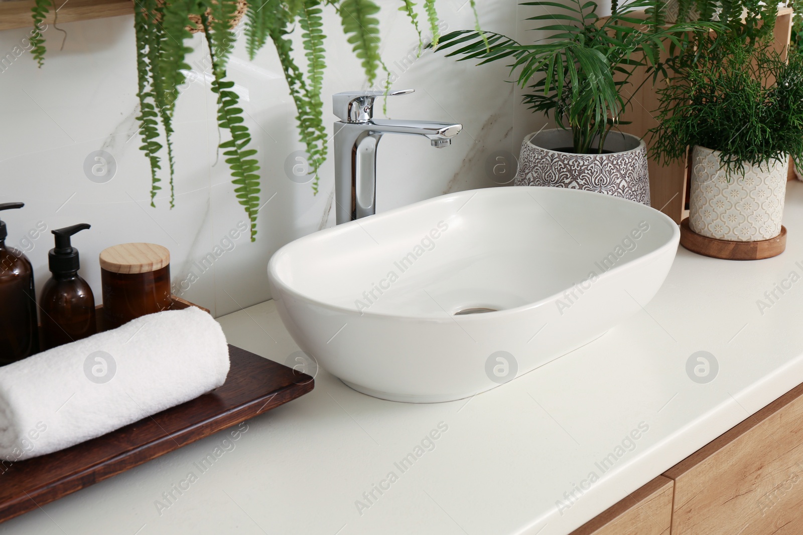 Photo of Counter with sink and many different houseplants near white marble wall