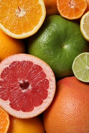 Photo of Different fresh whole and cut citrus fruits as background, top view