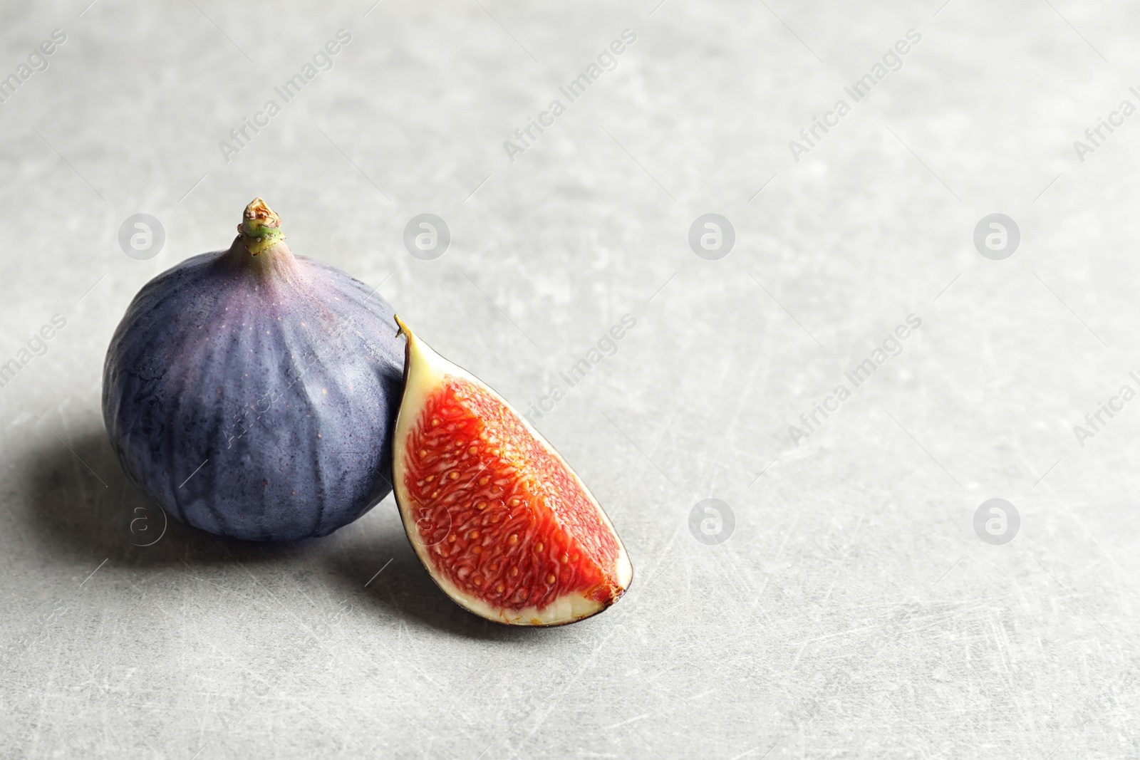 Photo of Fresh ripe figs and space for text on gray background. Tropical fruit