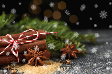 Different spices and fir tree branches on wooden table, closeup. Cinnamon, anise, cloves