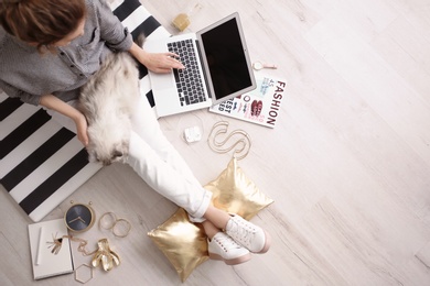 Female blogger with laptop and cat indoors, top view