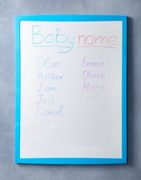 Photo of White board with baby names on grey wall