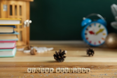 Photo of Wooden cubes with phrase Winter Holidays on table. Space for text