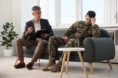 Professional psychotherapist working with military man in office