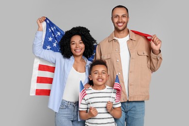4th of July - Independence Day of USA. Happy family with American flags on light grey background