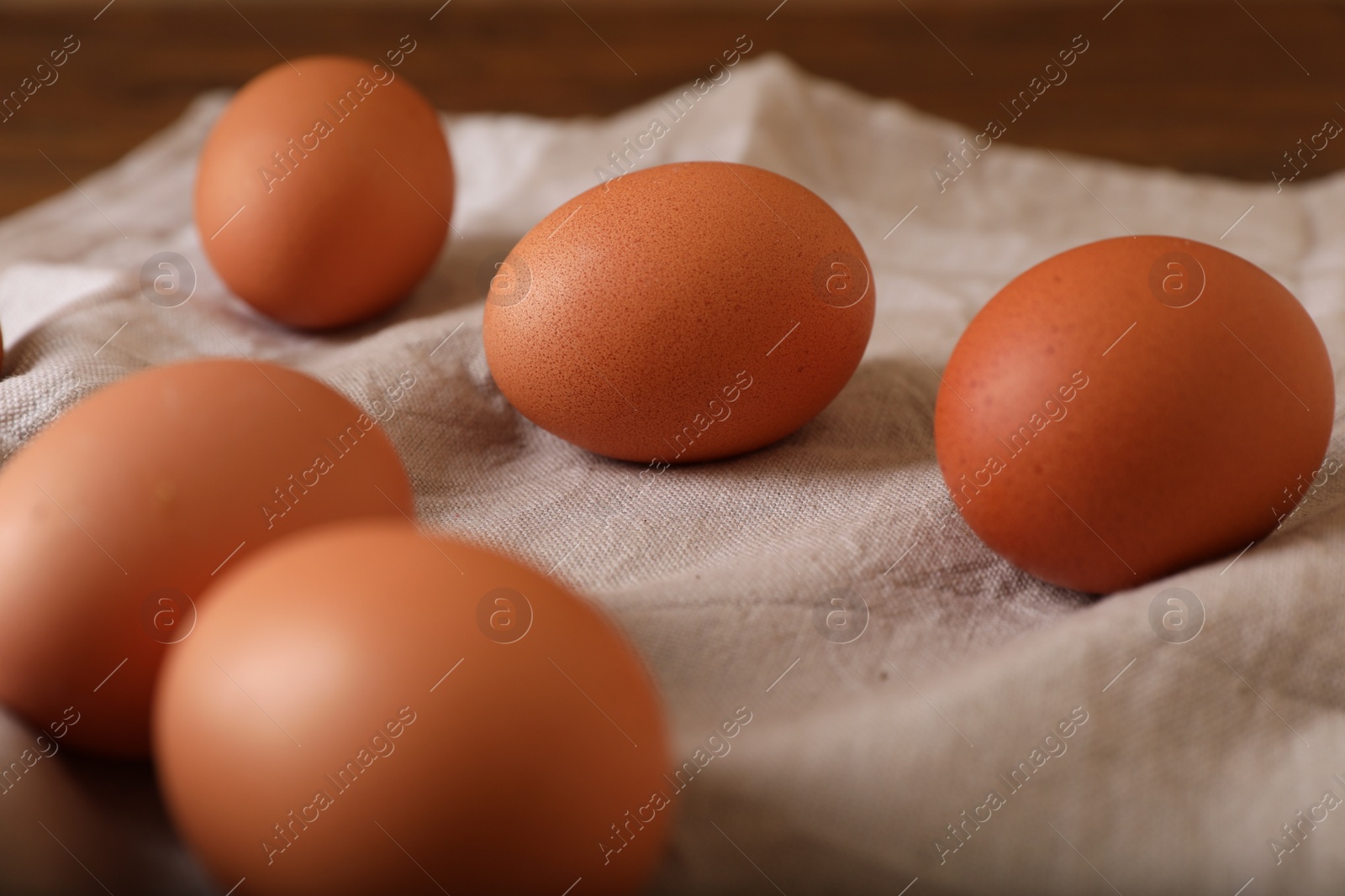 Photo of Raw brown chicken eggs on wooden table, closeup