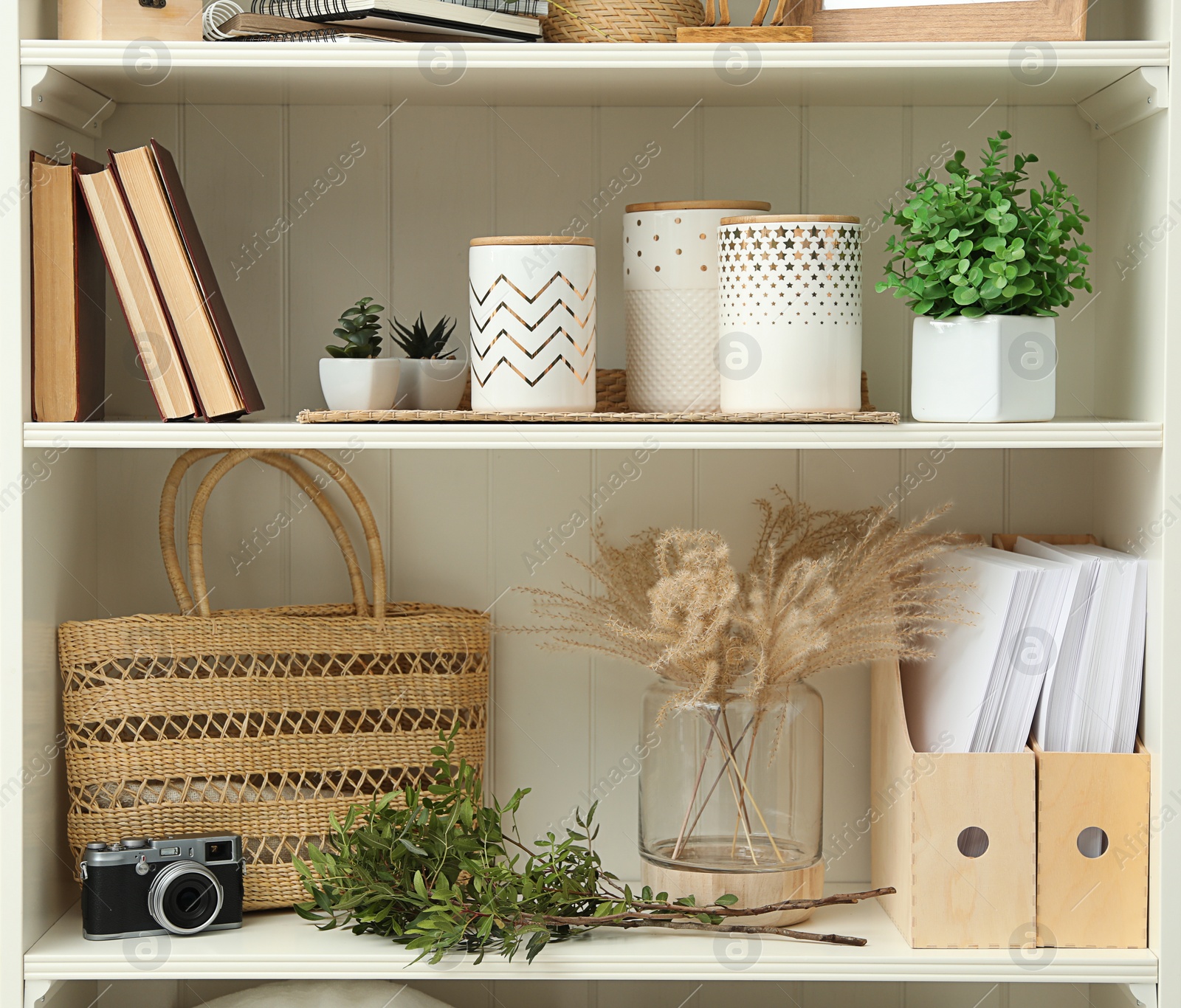 Photo of White shelving unit with different decorative elements