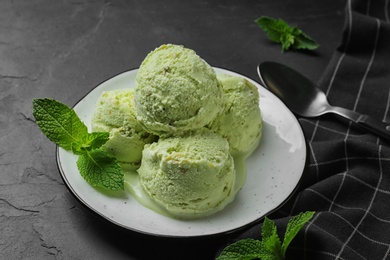 Photo of Delicious pistachio ice cream on dark table