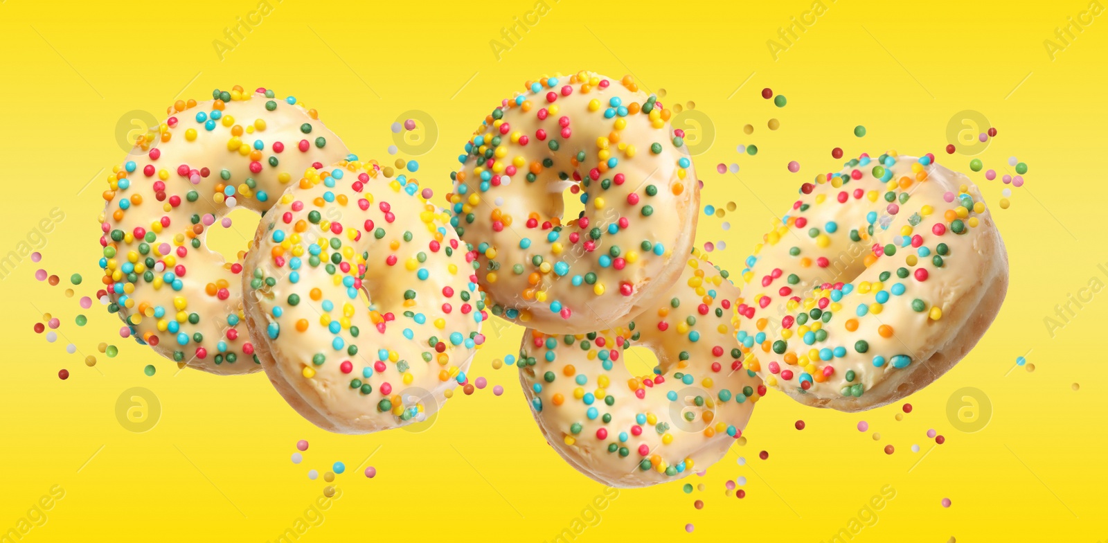 Image of Set of falling delicious donuts on yellow background. Banner design