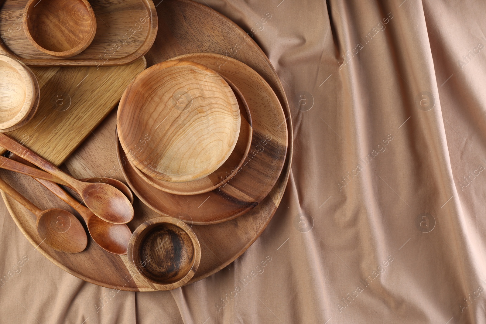 Photo of Set of wooden dishware and utensils on table, flat lay. Space for text