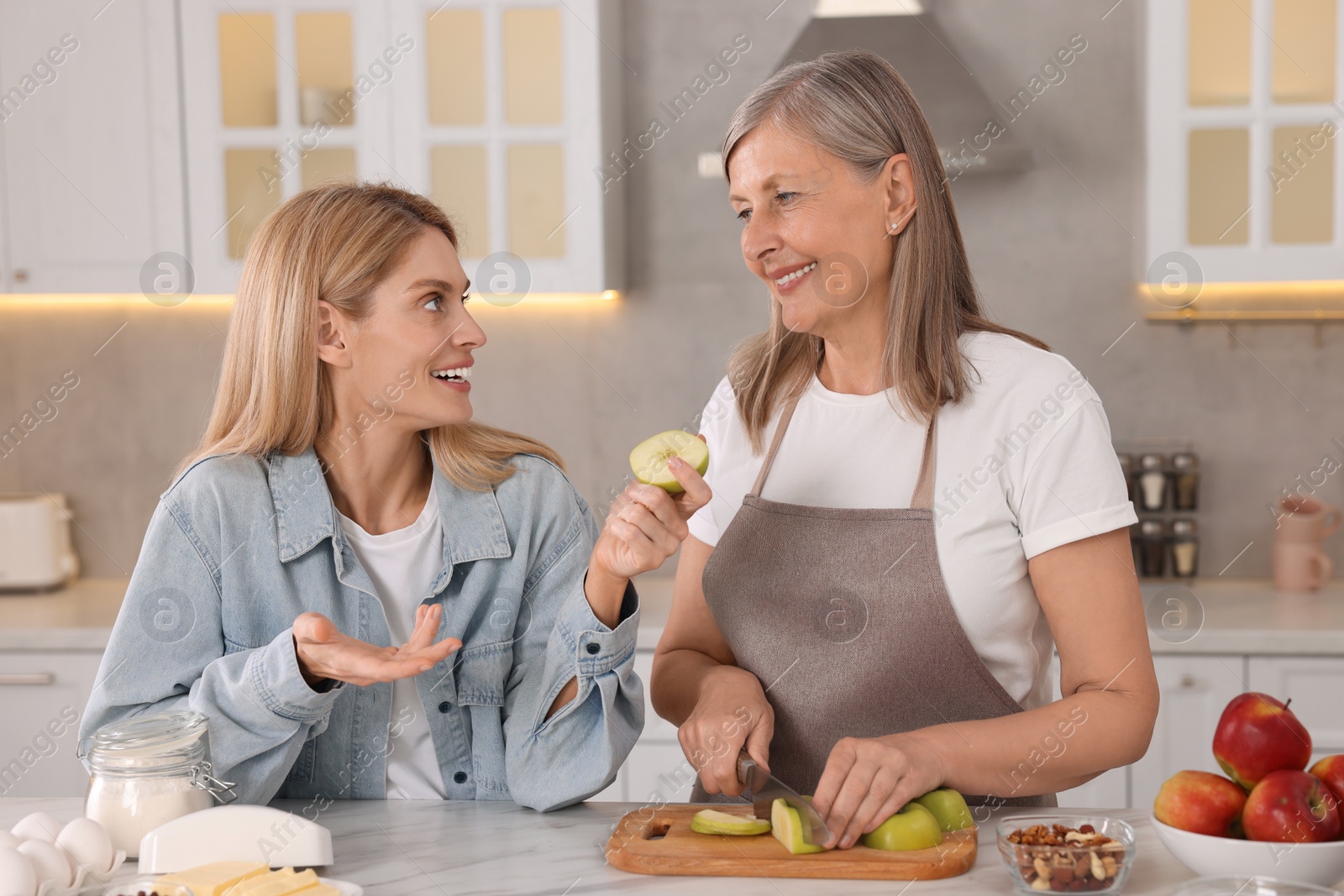 Photo of Happy mature mother and her daughter in kitchen