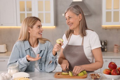 Photo of Happy mature mother and her daughter in kitchen