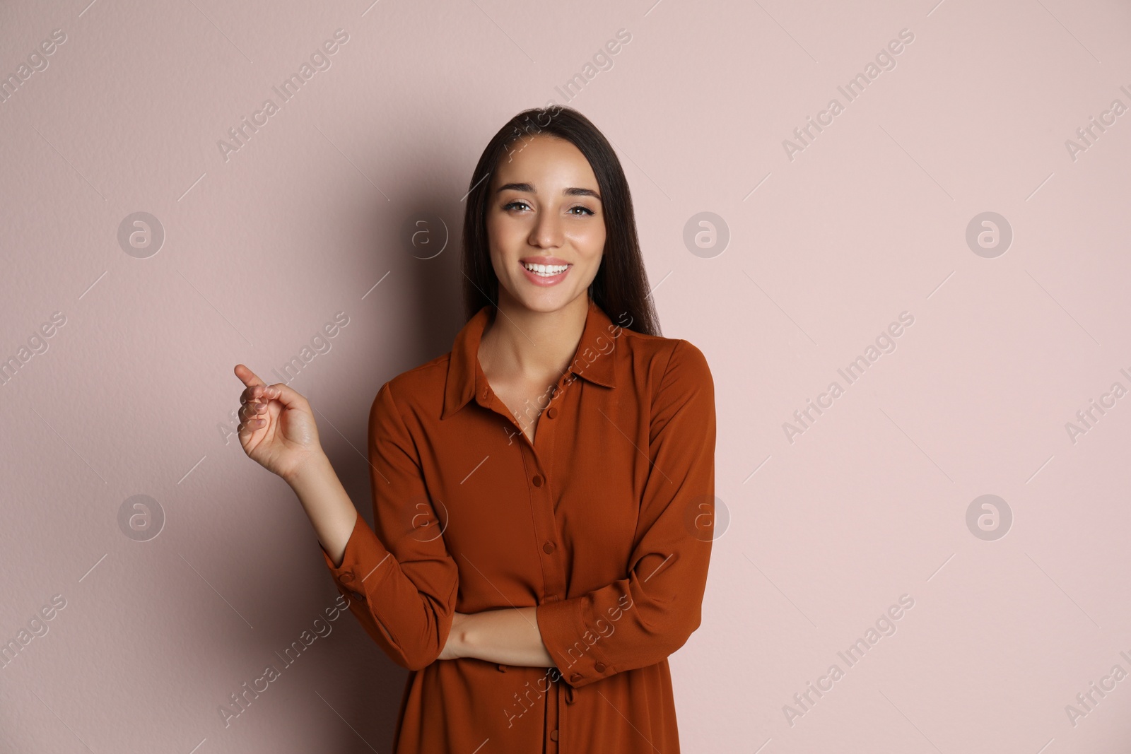 Photo of Young woman wearing stylish dress on pale pink background