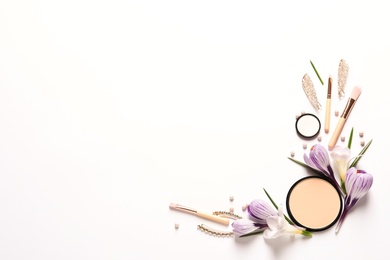 Different makeup products and flowers on white background, top view with space for text
