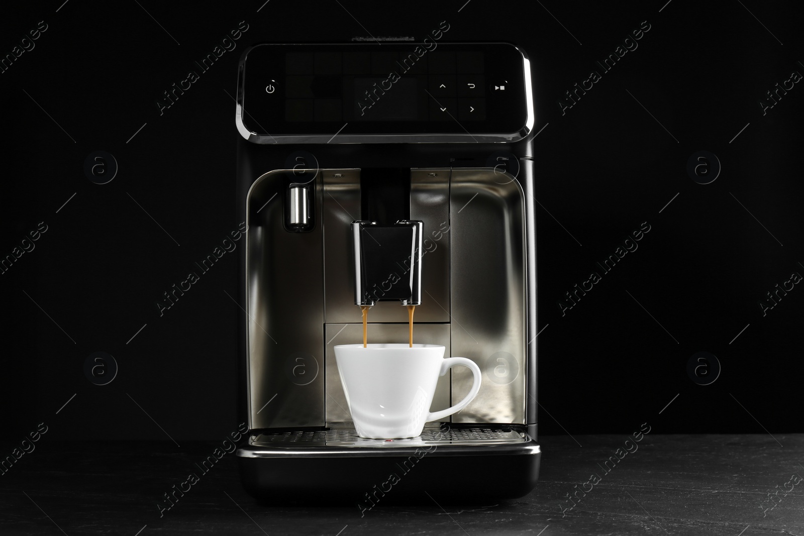 Photo of Making coffee with modern espresso machine on grey table against black background