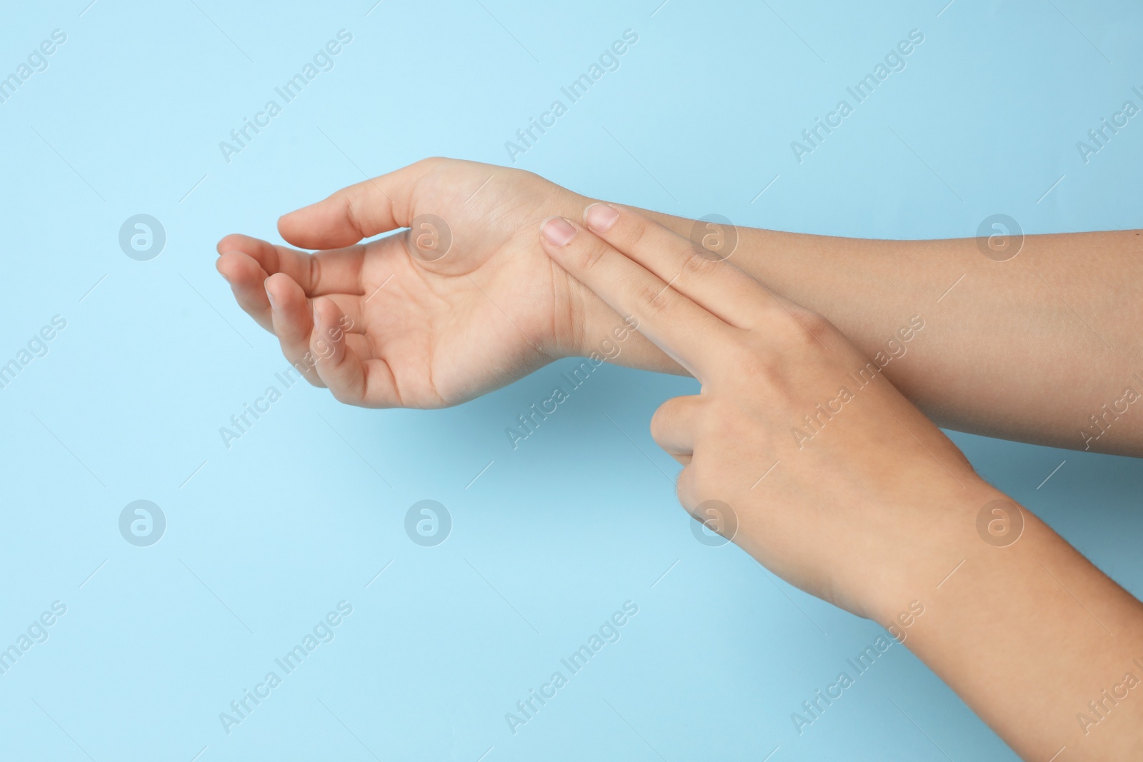 Photo of Woman checking pulse on color background, closeup