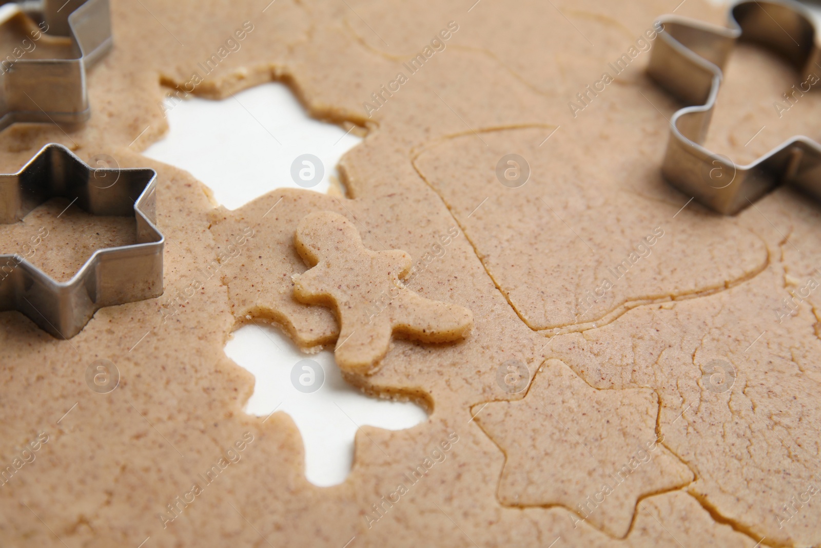 Photo of Homemade Christmas biscuits. Raw dough and cookie cutters on table, closeup