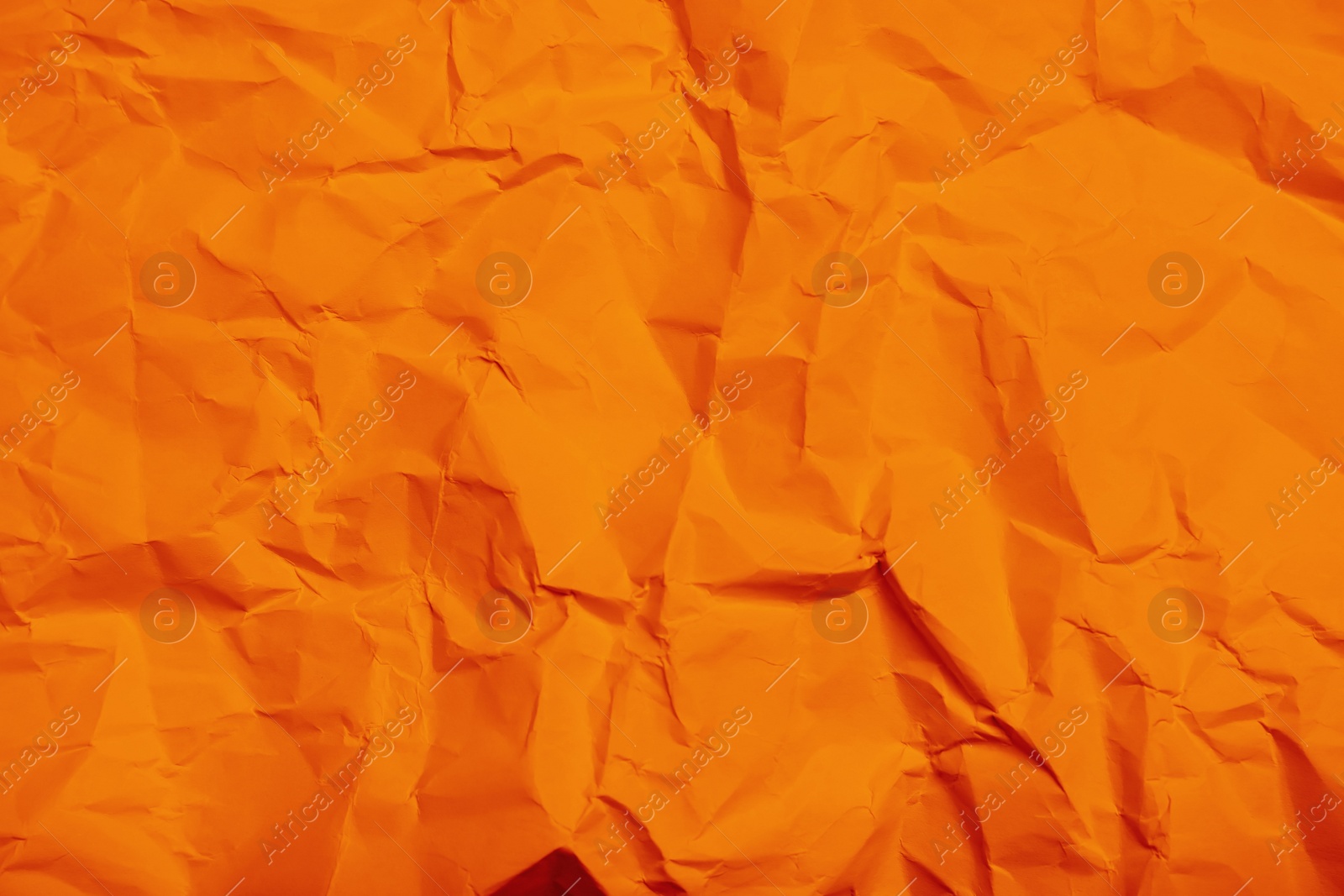 Image of Sheet of orange crumpled paper as background, closeup