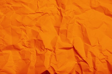 Sheet of orange crumpled paper as background, closeup