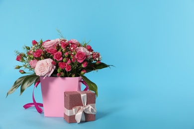 Photo of Beautiful bouquet of flowers and gift box on color background. Space for text