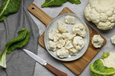 Cut and whole cauliflowers on grey table, flat lay