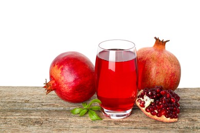 Photo of Refreshing pomegranate juice in glass, leaves and fruits on wooden table against white background