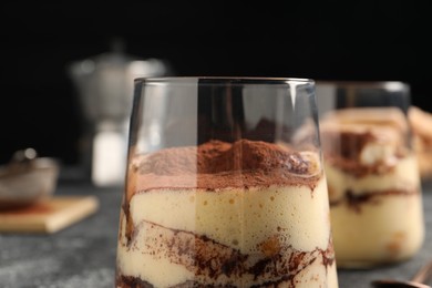 Photo of Delicious tiramisu in glass on table, closeup