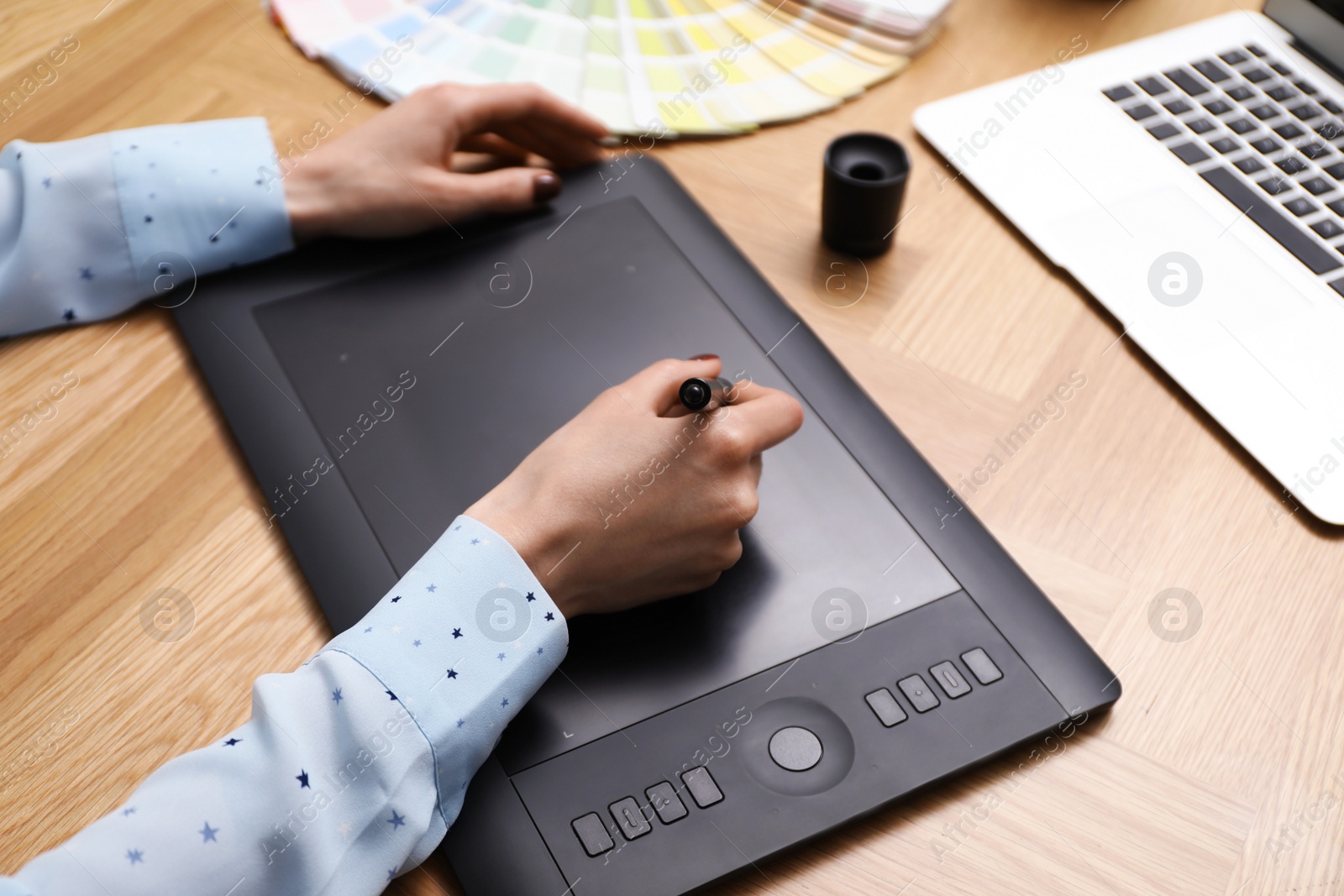 Photo of Professional designer with graphic tablet at wooden table, closeup