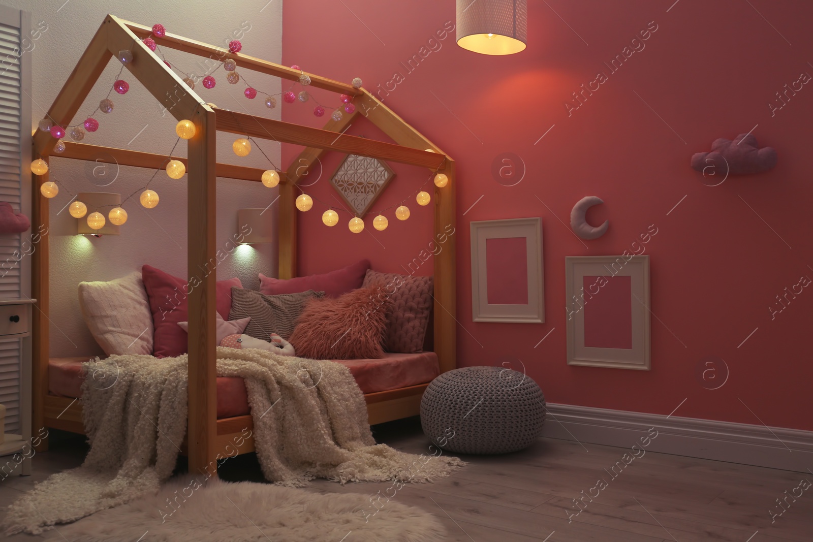 Photo of Child's room interior with comfortable bed and garland