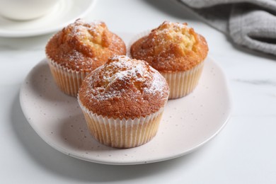 Photo of Delicious sweet muffins on white marble table, closeup