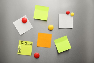 Photo of Paper sheets and magnets on refrigerator door