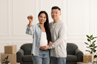 Photo of Pregnant woman and her husband with key in their new apartment