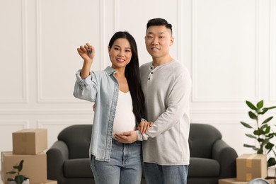 Pregnant woman and her husband with key in their new apartment