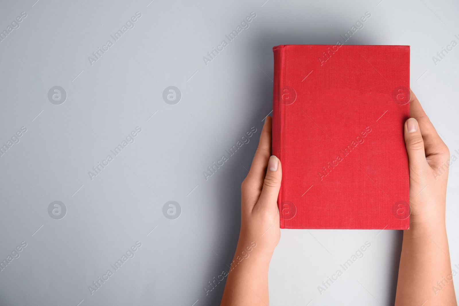 Photo of Woman with book on light grey background, top view. Space for design