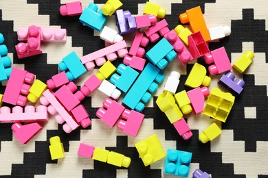 Colorful plastic building blocks on carpet, flat lay