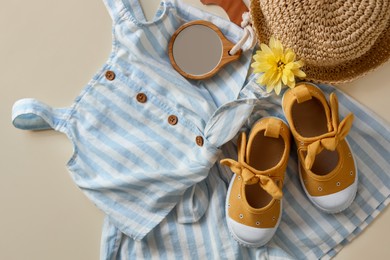 Photo of Stylish child clothes, shoes and accessories on beige background, flat lay