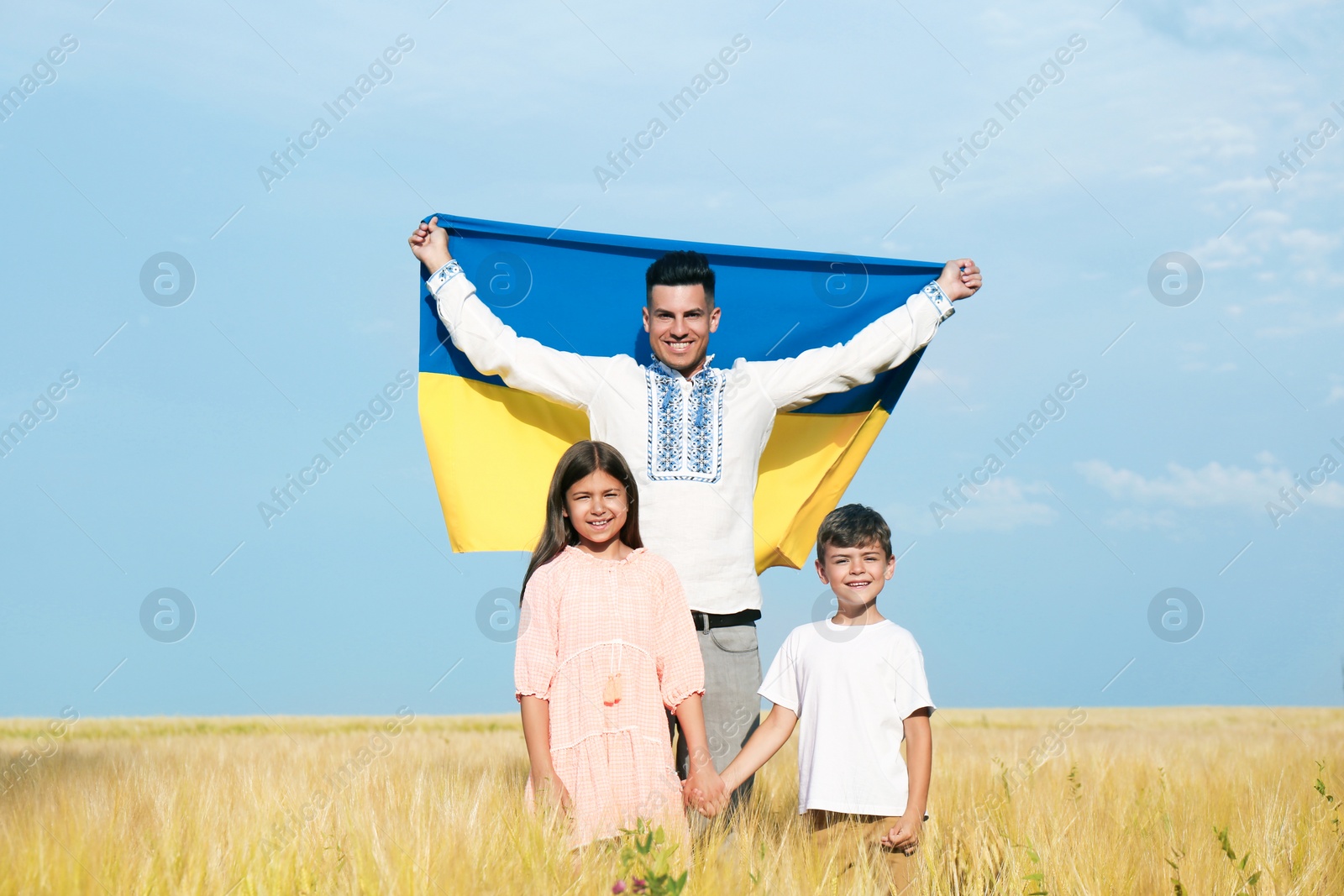Photo of Happy family with national flag of Ukraine in field