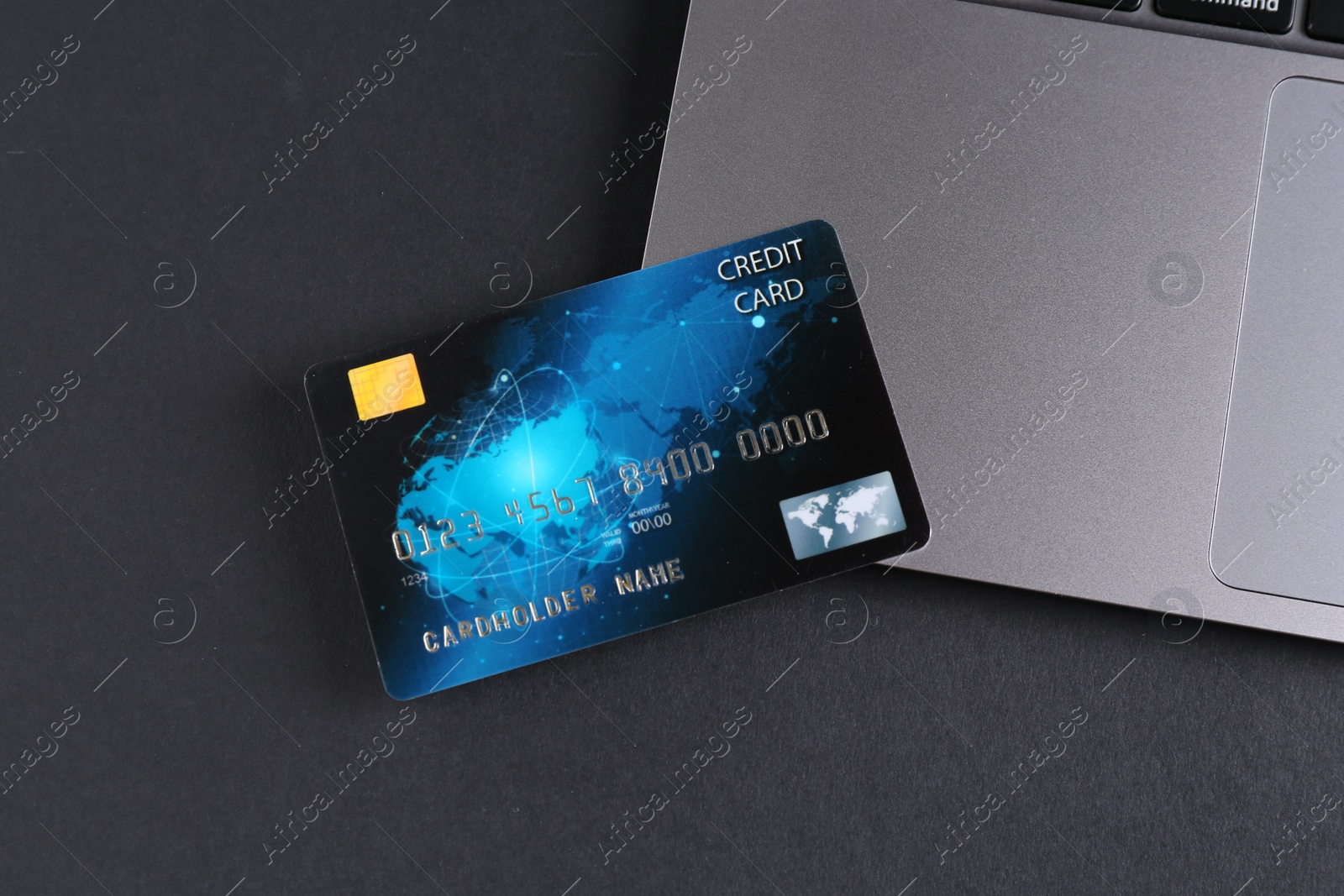 Photo of Credit card and laptop on grey table, flat lay