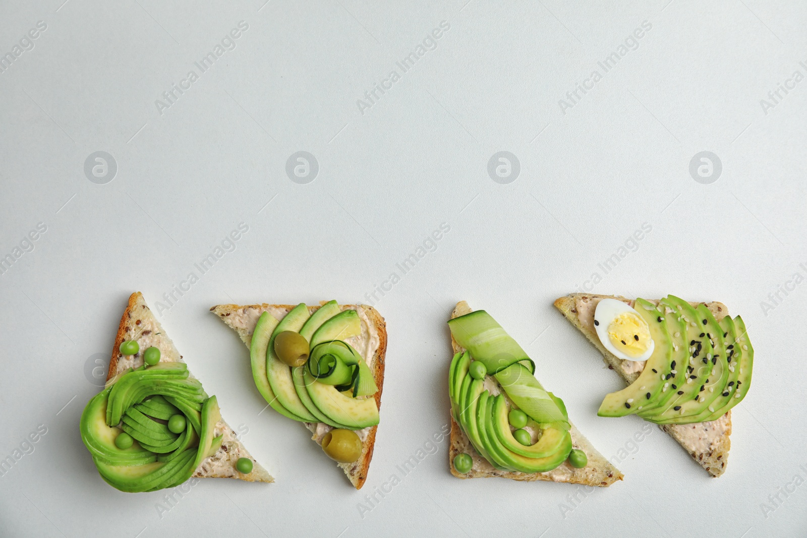 Photo of Flat lay composition with crisp avocado toasts on white background