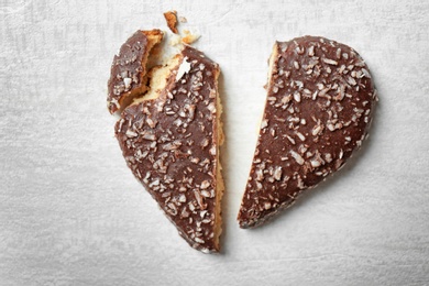 Photo of Broken heart shaped cookie on gray background, top view. Relationship problems