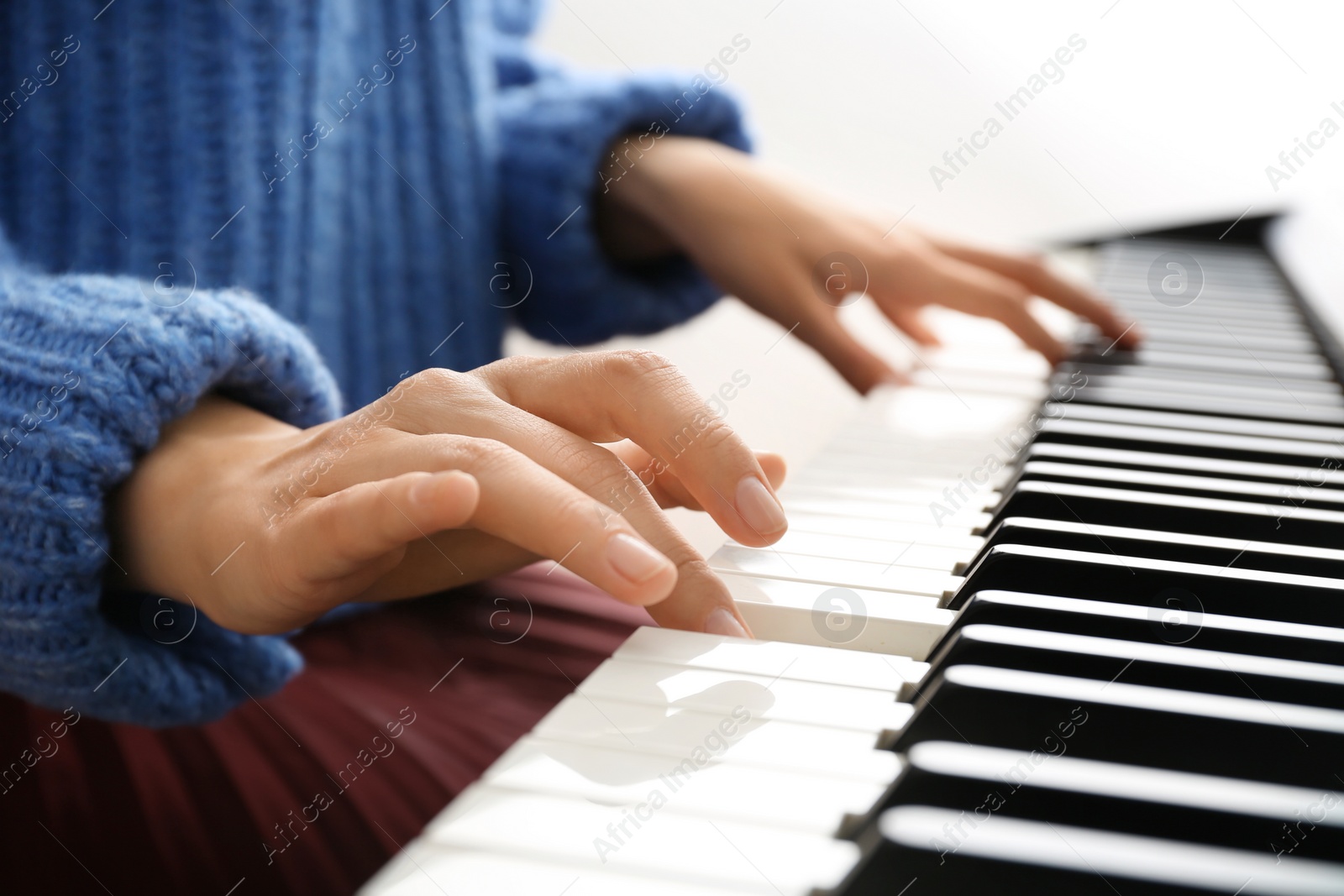 Photo of Young woman playing piano at home, closeup