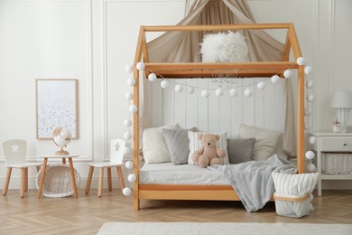 Photo of Stylish room for kid with house bed. Interior design