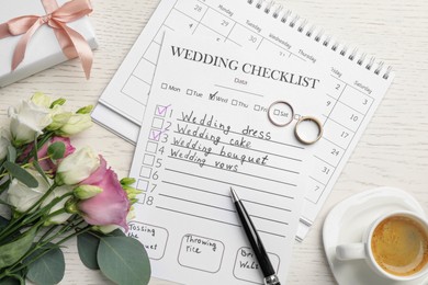 Flat lay composition with Wedding Checklist and calendar on wooden table