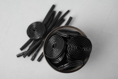 Photo of Tasty black liquorice candies on grey table, flat lay