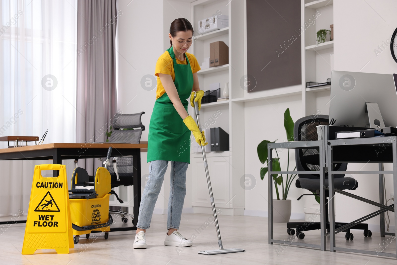 Photo of Cleaning service. Woman washing floor with mop in office