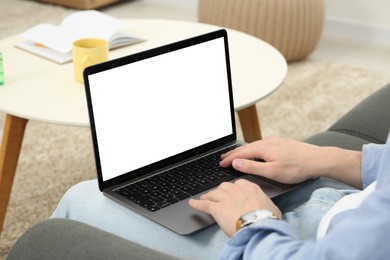 Photo of Man using laptop on couch indoors, closeup